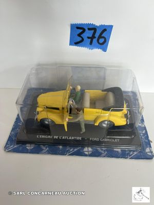 un petit camion jaune avec un homme debout à côté