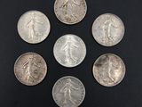 six silver coins are arranged in a circle on a black surface