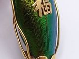 a green beetle that is sitting on a gold chain