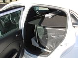 a white car with its door open and a bag in the passenger seat