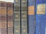 plusieurs vieux livres sont alignés sur une étagère