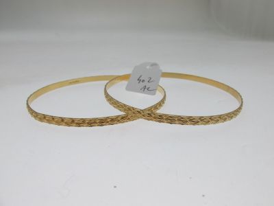 deux bracelets rigides en or ornés d'une breloque en forme de cœur