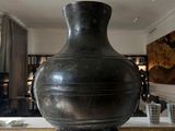 a large metal vase sitting on a marble table