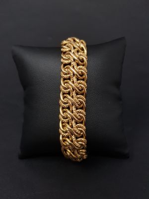 a close up of a gold bracelet on a black pillow