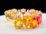 a gold ring with multi colored stones on it