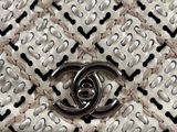 a close up of a white and black purse with a chain