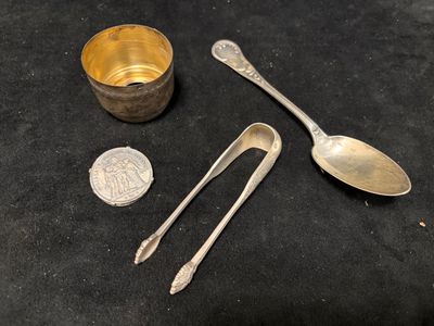 two spoons and a spoon rest on a table next to a coin