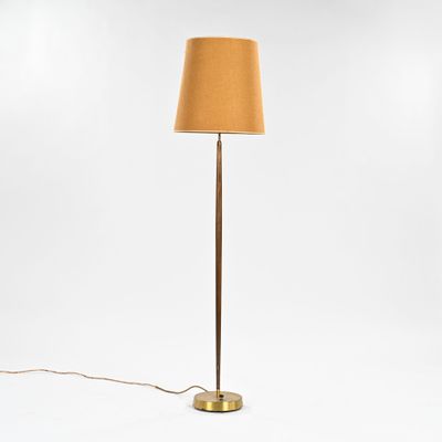 un lampadaire en laiton avec un abat-jour marron sur fond blanc