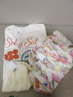 un t-shirt blanc et quelques autres objets posés sur un canapé