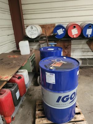 un fût bleu posé sur une palette dans un garage