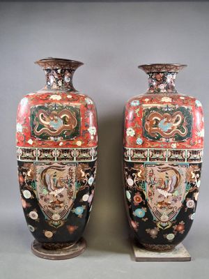 pair of vases sitting on top of a wooden stand on a gray surface