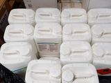 many containers of water sitting on a table in a room