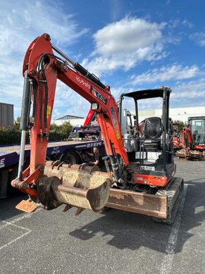 une pelleteuse rouge garée sur le parking