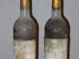 deux bouteilles de vin posées sur une table l'une à côté de l'autre