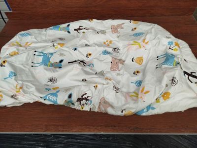 a white sheet with animals on it on a wooden table