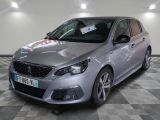 La voiture argentée est garée dans le showroom, sur le sol à damier.