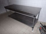 une table en métal avec un plateau noir dans une pièce