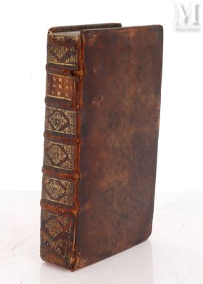 an old book sitting on top of a white table next to a white wall