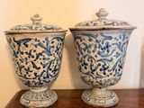 two blue and white vases sitting on a wooden table