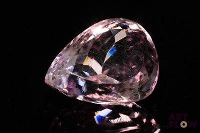gros plan d'un diamant rose sur une surface noire