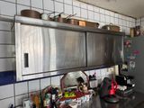 a kitchen with a refrigerator, stove, sink, and other items on the counter