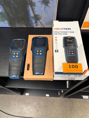 trois téléphones portables posés sur une table à côté d'une boîte
