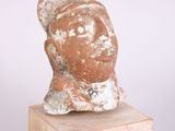 an image of a sculpture of a woman ' s head on a wooden base