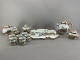 un ensemble d'objets en porcelaine comprenant une théière, une soucoupe et un plateau