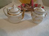 deux théières blanches et or posées sur une table