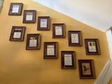 many framed pictures on the wall of this room