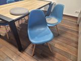 a wooden table with blue chairs and a plate on it