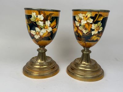 two vases with flowers painted on them sitting on a table