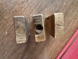 three gold bars sitting on a table next to a pink purse