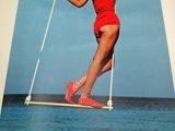 a book with a picture of a woman in a red bathing suit on a swing