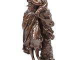 une statue en bronze représentant une femme tenant un enfant et un chien dans ses bras