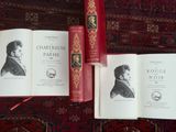 trois livres posés sur un tapis rouge