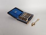 des couverts dans un étui bleu, avec une cuillère et un repose-cuillère