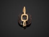 a close up of a gold plated pendant with a brown stone