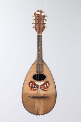 a guitar hanging from a string on a white wall