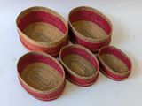 six baskets are lined up on a white surface