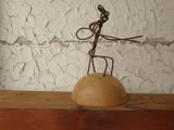 a metal sculpture of a man on top of a wooden table