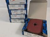 trois cartons remplis de livres sont empilés les uns sur les autres sur une surface blanche