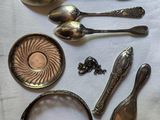a lot of silver spoons and other silverware on a table