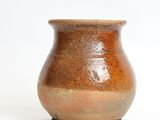 a small brown vase sitting on a white surface