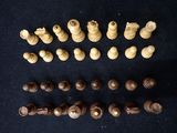 an assortment of wooden chess pieces on a black surface