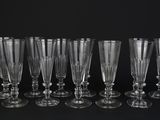 six verres à vin vides alignés sur une surface noire