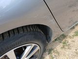 a close up of a car ' s tire on a dirt road