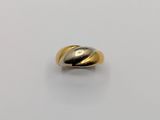 gros plan d'une bague en or et en argent sur une surface blanche