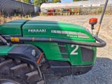 a green tractor that is parked in the dirt