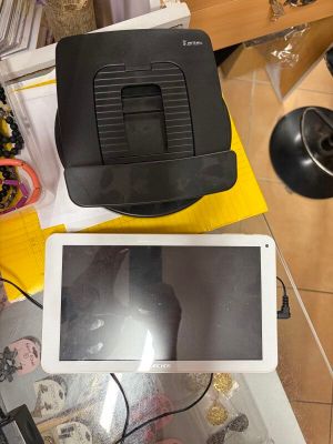 une tablette posée sur une table, à côté d'un ordinateur portable